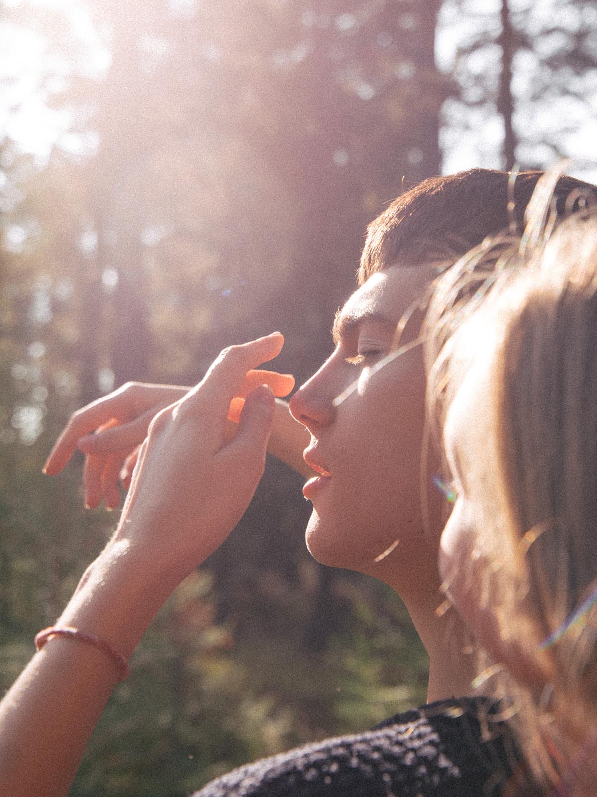 Kille i motljus tar på sitt ansikte utan akne